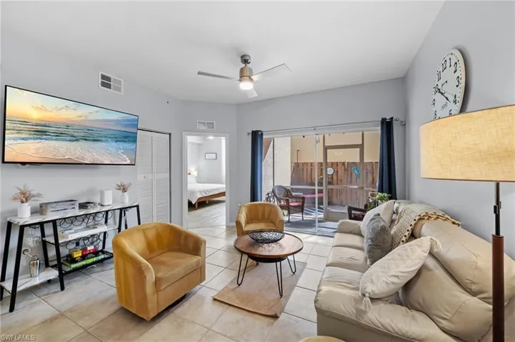 Living area featuring tiled flooring, a ceiling fan, and sliding glass doors leading to an outdoor space
