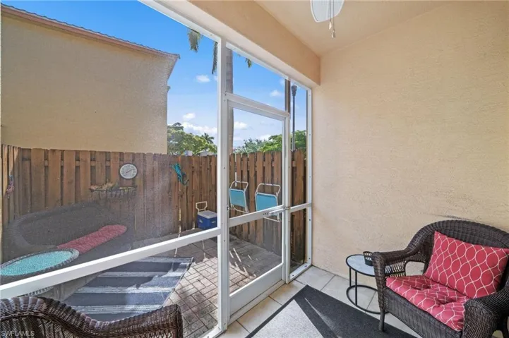 The screened patio provides a sheltered outdoor space with ample natural light, featuring a tiled floor and a ceiling fan