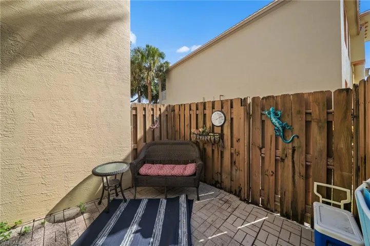 The outdoor patio features a privacy fence and a paver floor