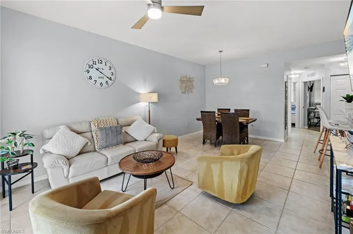 The property features an open living and dining area with light-colored tile flooring and a ceiling fan