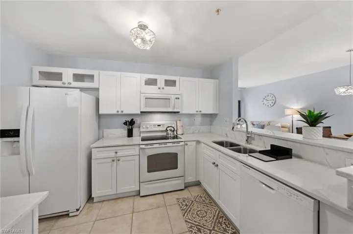 The kitchen features white cabinetry, white appliances, and light-colored countertops