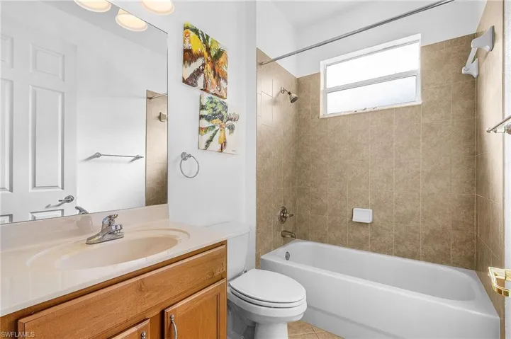 Full bath with vanity, shower / bath combination, and tile patterned flooring