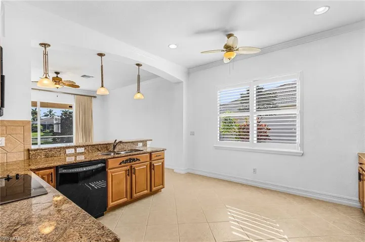 Kitchen featuring black appliances, ceiling fan, ornamental molding, brown cabinetry, and a peninsula