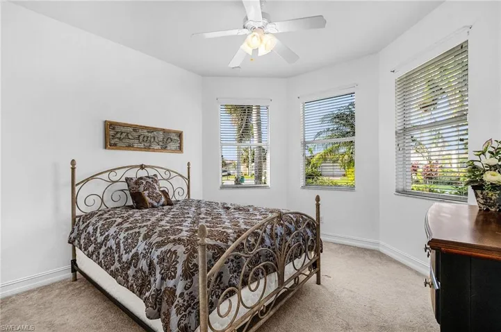Bedroom with light colored carpet and a ceiling fan