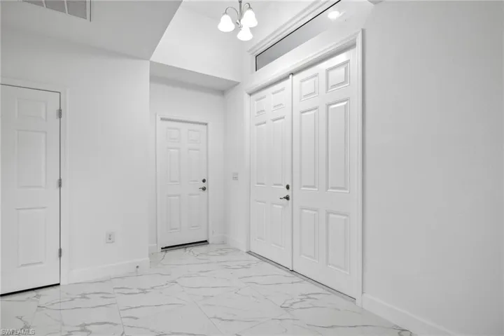 Corridor featuring a notable chandelier