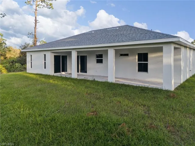 Rear view of house featuring a patio area and a yard