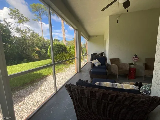 Screened lanai with a ceiling fan and an outdoor living space