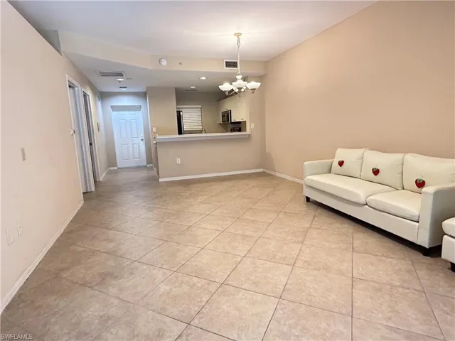 Living area with a chandelier and light tile patterned flooring