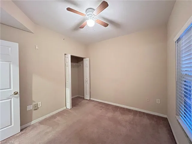 Unfurnished bedroom with carpet floors, a ceiling fan, and a closet