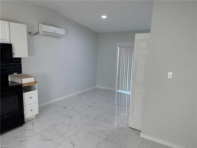 Dining area with light marble finish tile flooring, a wall mounted mini-split AC, and recessed lighting
