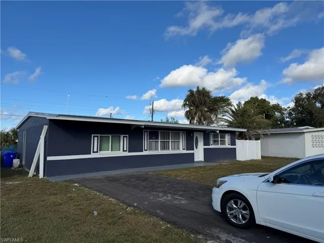 Ranch-style home featuring a front lawn and stucco siding