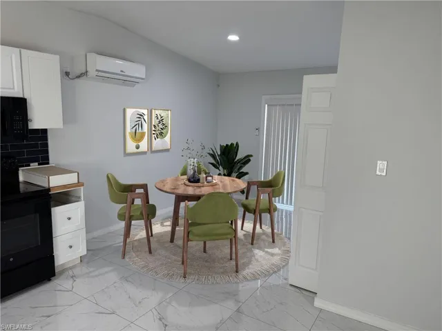 Virtually Staged - Dining area with light marble finish tile flooring, a wall mounted mini-split AC, and recessed lighting