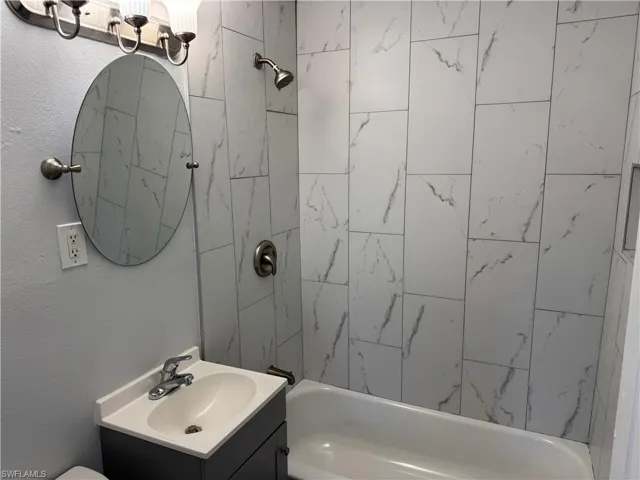 Full Guest bath featuring vanity and shower / tub combination