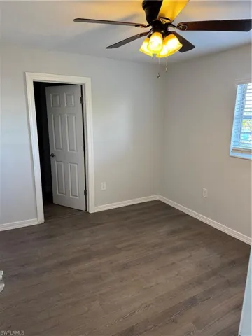 Unfurnished Primary room featuring dark wood-style LVP flooring and ceiling fan