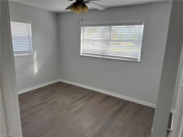 Front Guest Bedroom featuring ceiling fan, dark wood-style LVP floors, and multiple windows