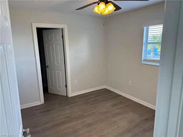 Unfurnished Primary room featuring dark wood-style LVP flooring and ceiling fan