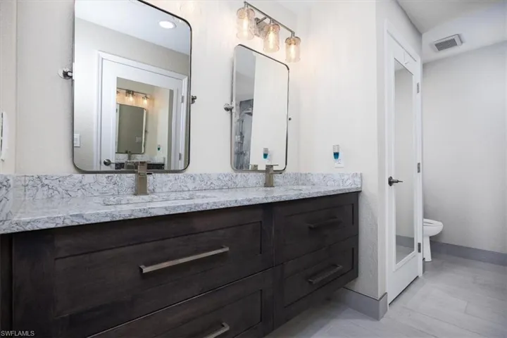 Bathroom featuring double vanity and toilet