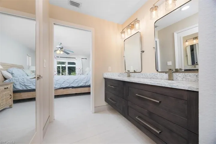 Ensuite bathroom featuring double vanity and ceiling fan