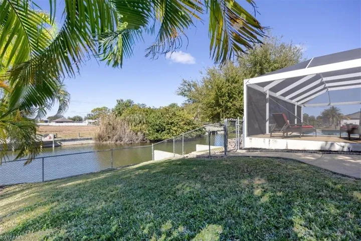 Fenced backyard with glass enclosure, a sunroom, and a water view