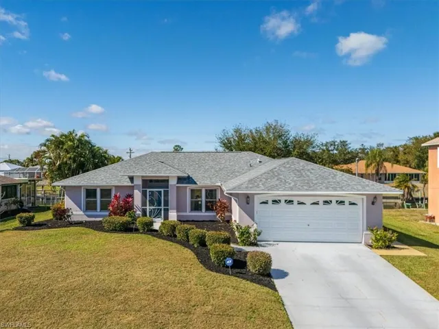 Single story home featuring a front lawn, a shingled roof, concrete driveway, an attached garage, and stucco siding