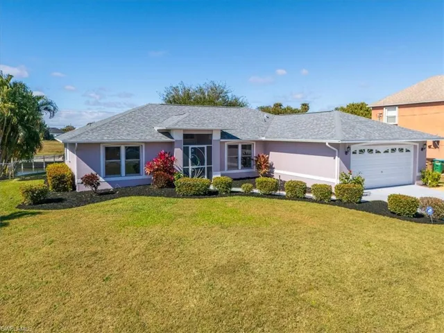 Ranch-style home with stucco siding, a front lawn, an attached garage, and concrete driveway