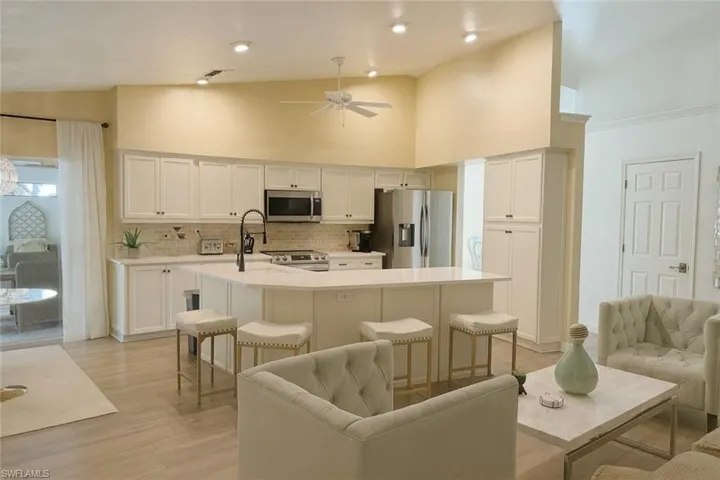 Kitchen with high vaulted ceiling, stainless steel appliances, and a  kitchen island