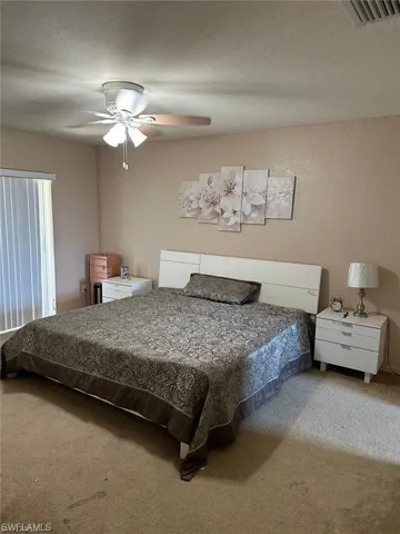 Bedroom featuring ceiling fan and carpet