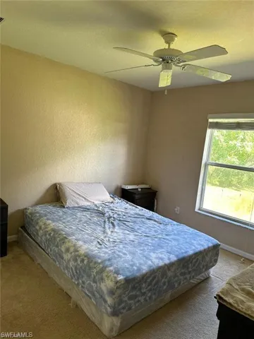 Carpeted bedroom with ceiling fan