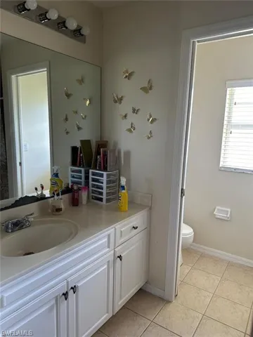 Bathroom with tile patterned floors, vanity, and toilet