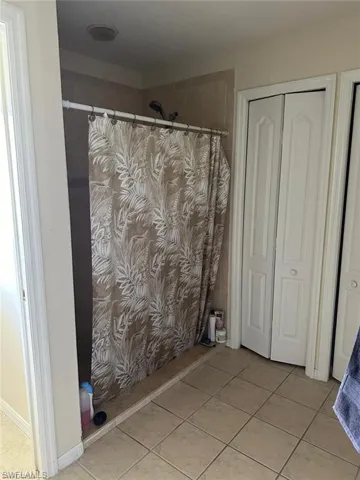 Bathroom featuring tile patterned floors and a shower with shower curtain