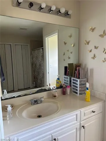 Bathroom with a shower with shower curtain and vanity