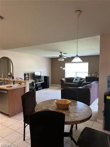 Dining area featuring light tile patterned floors, ceiling fan, and sink