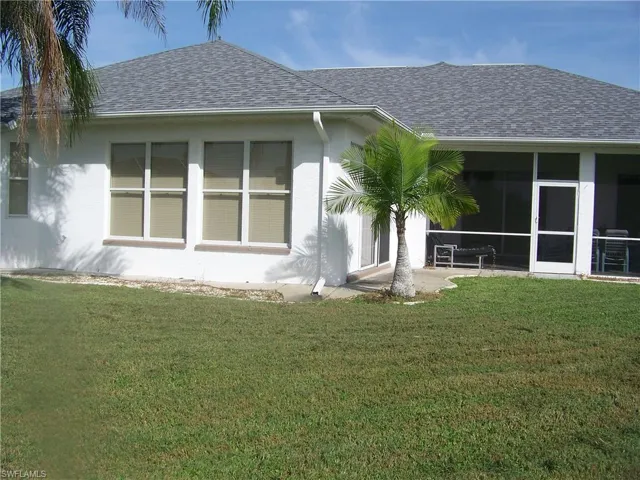 Rear view of house featuring good size screened lanai and rear family room windows