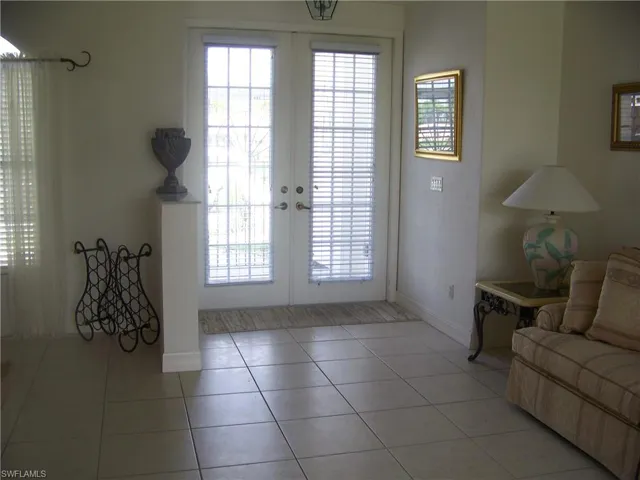 Entryway with French doors, marble topped knee wall and tiled floor