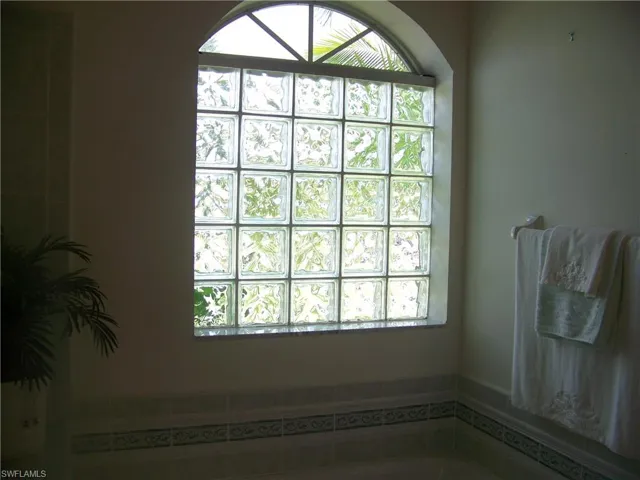 Custom window over spa in master bath. Glass block for privacy.