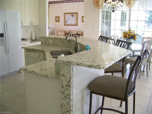 Kitchen breakfast bar with subway tile. Will hold up to 6 stools comfortably. Built in dual sinks/dishwasher.