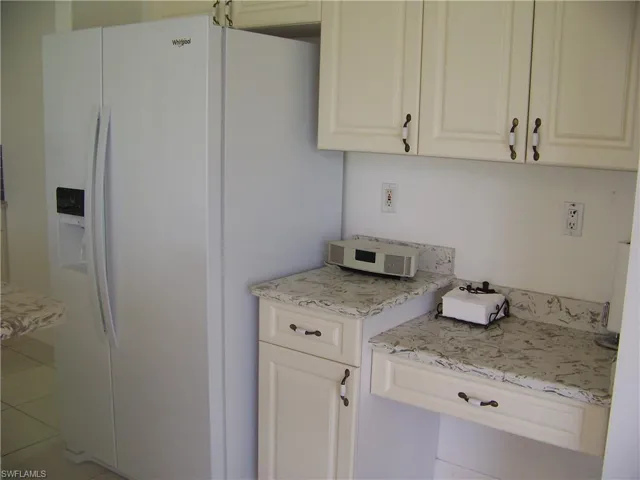 Built -in desk in kitchen with side by side refrigerator/ice and water.