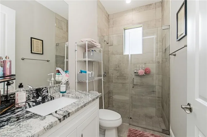 Vanity with a polished granite countertop, rectangular undermount sink, and chrome faucet