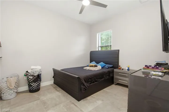 Recessed ceiling fan, window with blinds, light-colored walls, and large format floor tiling