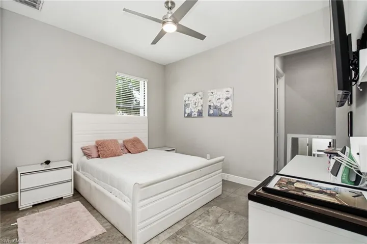 Recessed window with blinds, ceiling fan with integrated lighting, and tile flooring