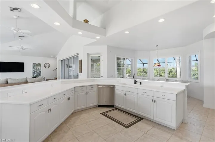 Kitchen featuring recessed lighting, white cabinetry, open floor plan, dishwasher, and decorative light fixtures
