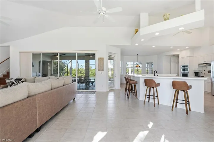 Living room featuring recessed lighting, light tile patterned flooring, a sunroom, high vaulted ceiling, and ceiling fan