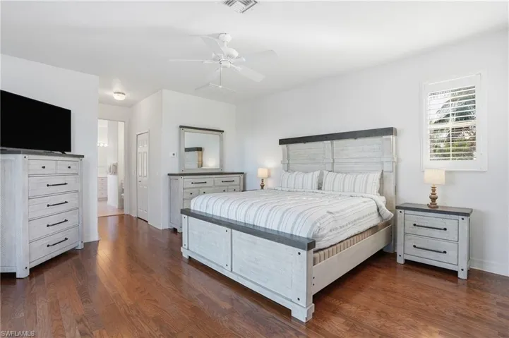 Bedroom featuring dark wood finished floors, a ceiling fan, and a closet