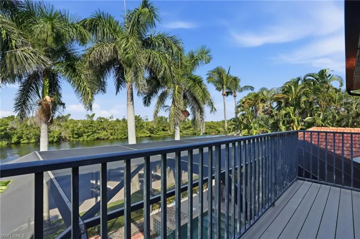 Wooden deck with a water view and view of wooded area