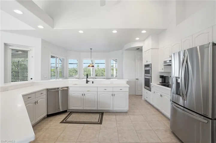 Kitchen with appliances with stainless steel finishes, recessed lighting, decorative light fixtures, white cabinets, and light countertops