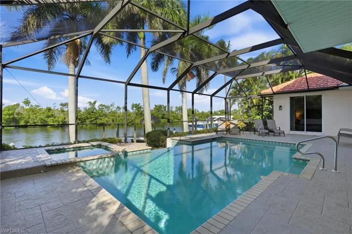 View of swimming pool featuring a patio area, a water view, and a lanai