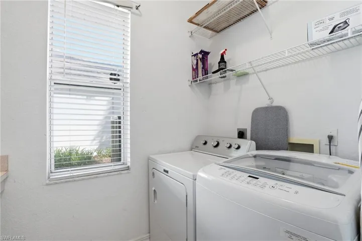 Washroom featuring a textured wall and washer and clothes dryer