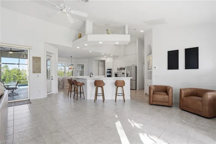 Kitchen featuring light countertops, high vaulted ceiling, a kitchen breakfast bar, open floor plan, and a large island