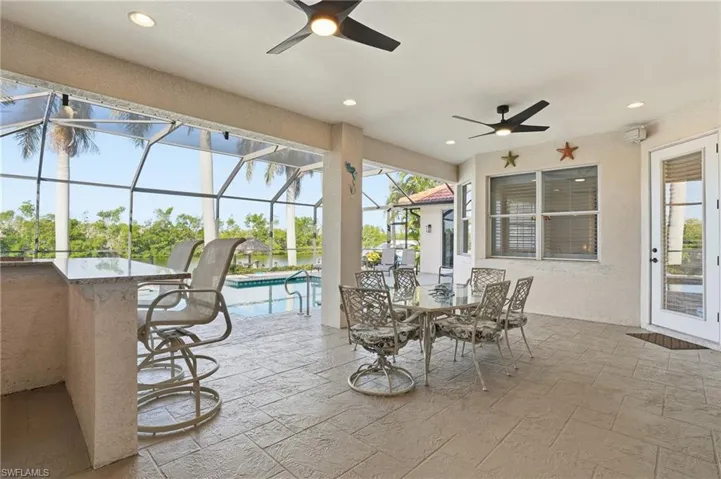 View of patio with a sunroom, a ceiling fan, and a lanai