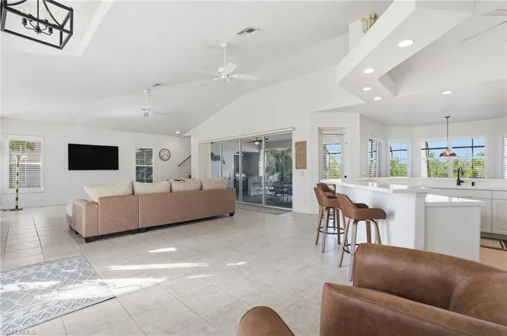 Living area with plenty of natural light, recessed lighting, ceiling fan, light tile patterned floors, and high vaulted ceiling
